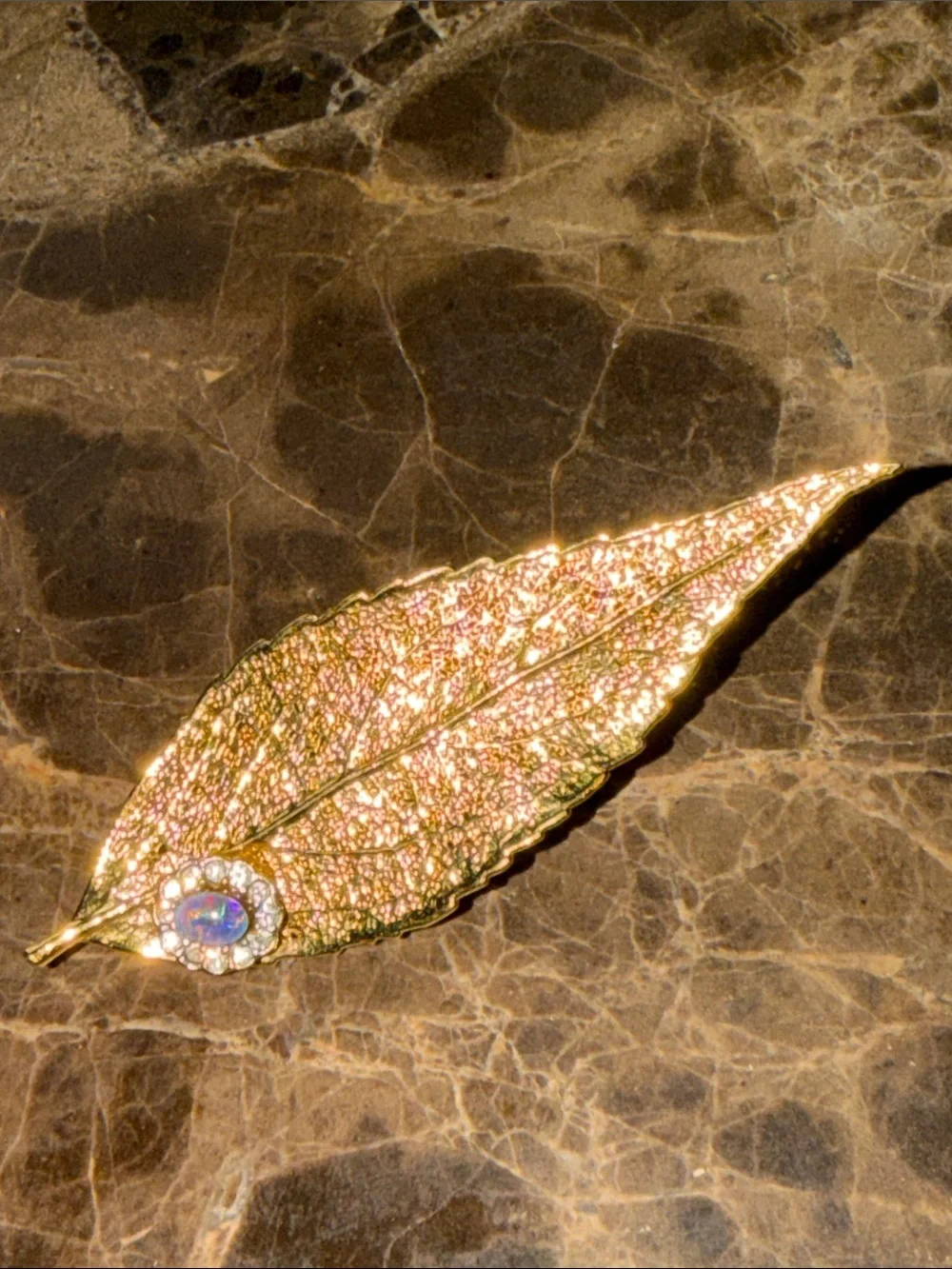 Beautiful gold plated leaf with a cabochon opal and crystal surrounding